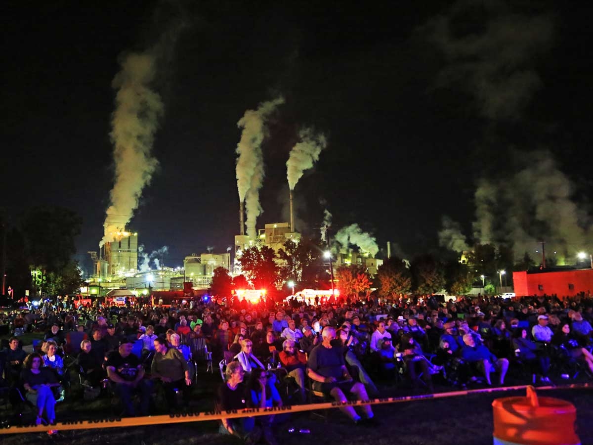 The crowd at the Grit and Grace benefit, with the Evergreen paper mill in the background. Jeff Delannoy photo