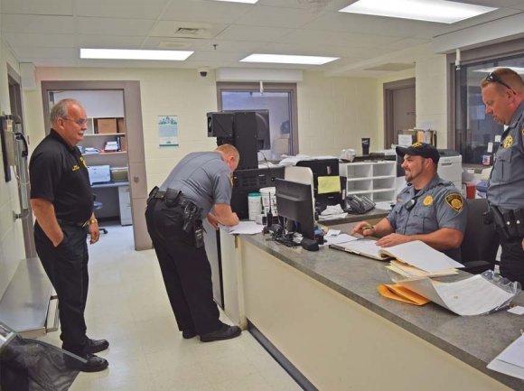 Swain County Sheriff Curtis Cochran checks in with detention officers at the booking desk at the jail. Jessi Stone photo