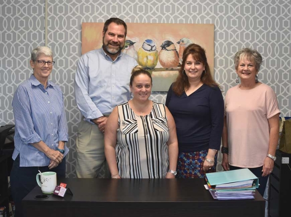 With victim advocate Ruby Lawrence in the center, board members Mary Ann Lochner (from left), Bob Cochran, Heather Baker and Marsha Lee Baker stand in the office of Jackson County’s Center for Domestic Peace, which operates in partnership with REACH of Macon County. Holly Kays photo