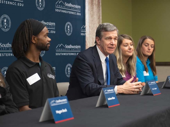 Gov. Roy Cooper (center) with Finish Line Grant recipients Andrew Allen (left) and Abbie Turner (right).