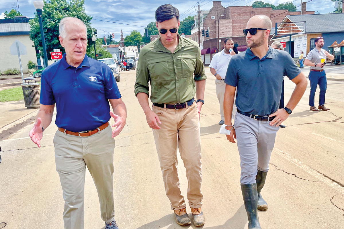 Then-town Manager Nick Scheuer (right) walks through flood-ravaged Canton on Aug. 19, 2021, with Sen. Thom Tillis (left) and Mayor Zeb Smathers. Cory Vaillancourt photo