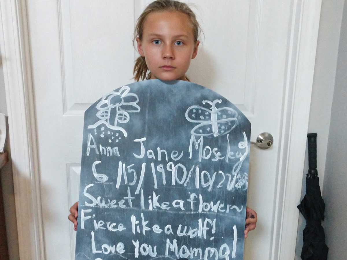 Gracie Parker, of Macon County, holds a tombstone memorializing her mother. Donated photo