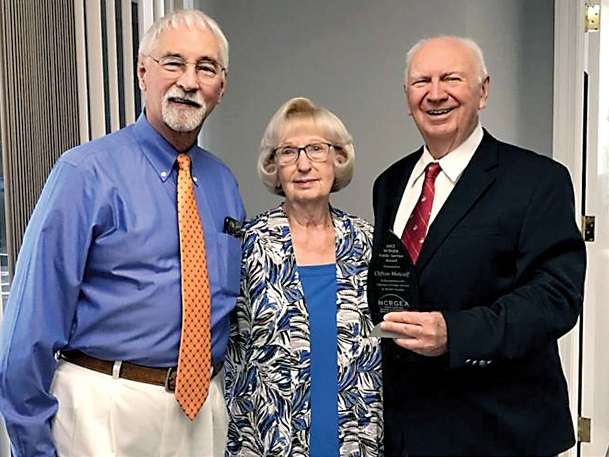 Clifton Metcalf (right) with his wife, Marie, receives the inaugural lifetime achievement award from the North Carolina Retired Governmental Employees’ Association, presented by the group’s president, Van Langston (left).