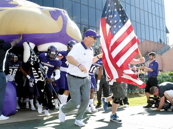 Western Carolina University football coach Mark Speir shows his Catamount spirit coming out of the tunnel.