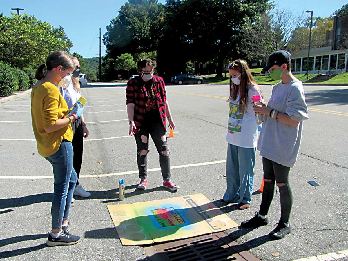 Haywood Early College students stencil storm drains on the Haywood Community College campus. Donated photo