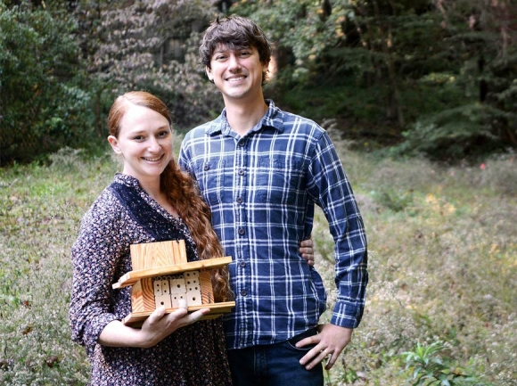 Jill Jacobs and her husband Brannen Basham hold up one of their handmade bee houses amid flowering native plants at their home in Waynesville. Holly Kays photos