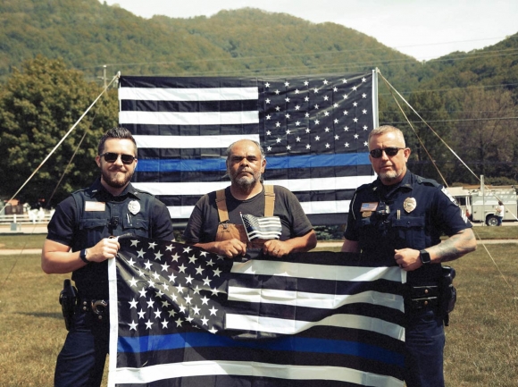 Maggie Valley police officers pose in front of the Back the Blue flag. Jeffrey Delannoy photo