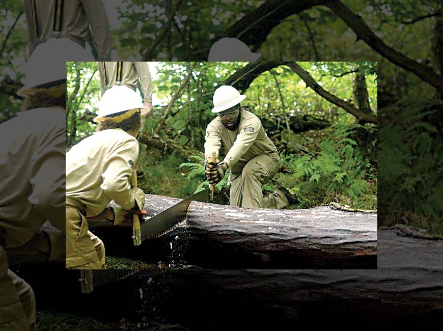 CCNC Crew Members Alicia Pennachio and Peter Chege use a crosscut saw on a downed tree. Donated photo 