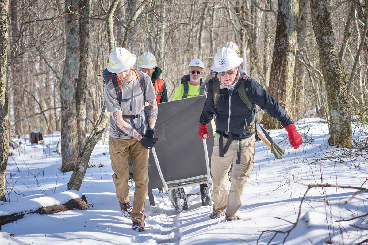 Volunteers use the Zebmobile to haul a bear box through fresh show. David Huff photo