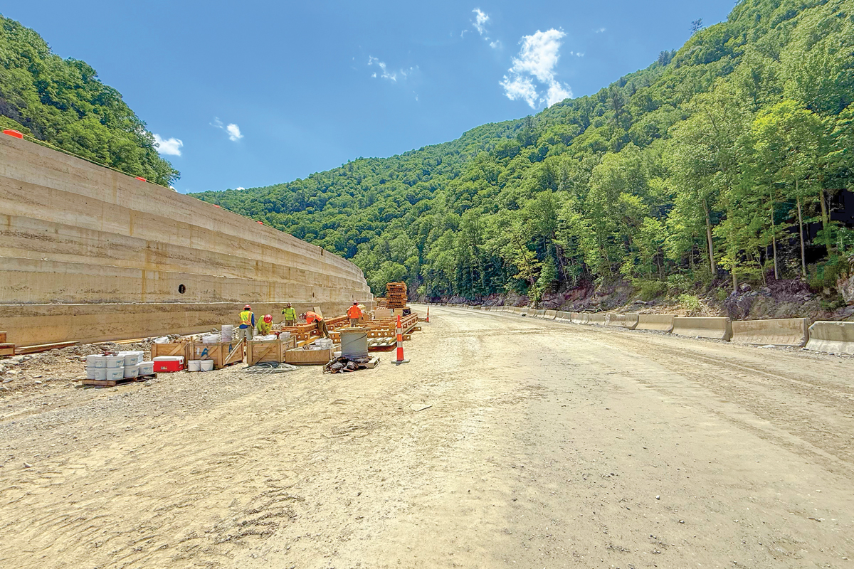 The roller compacted concrete is being layered along the embankment to stabilize the highway. 