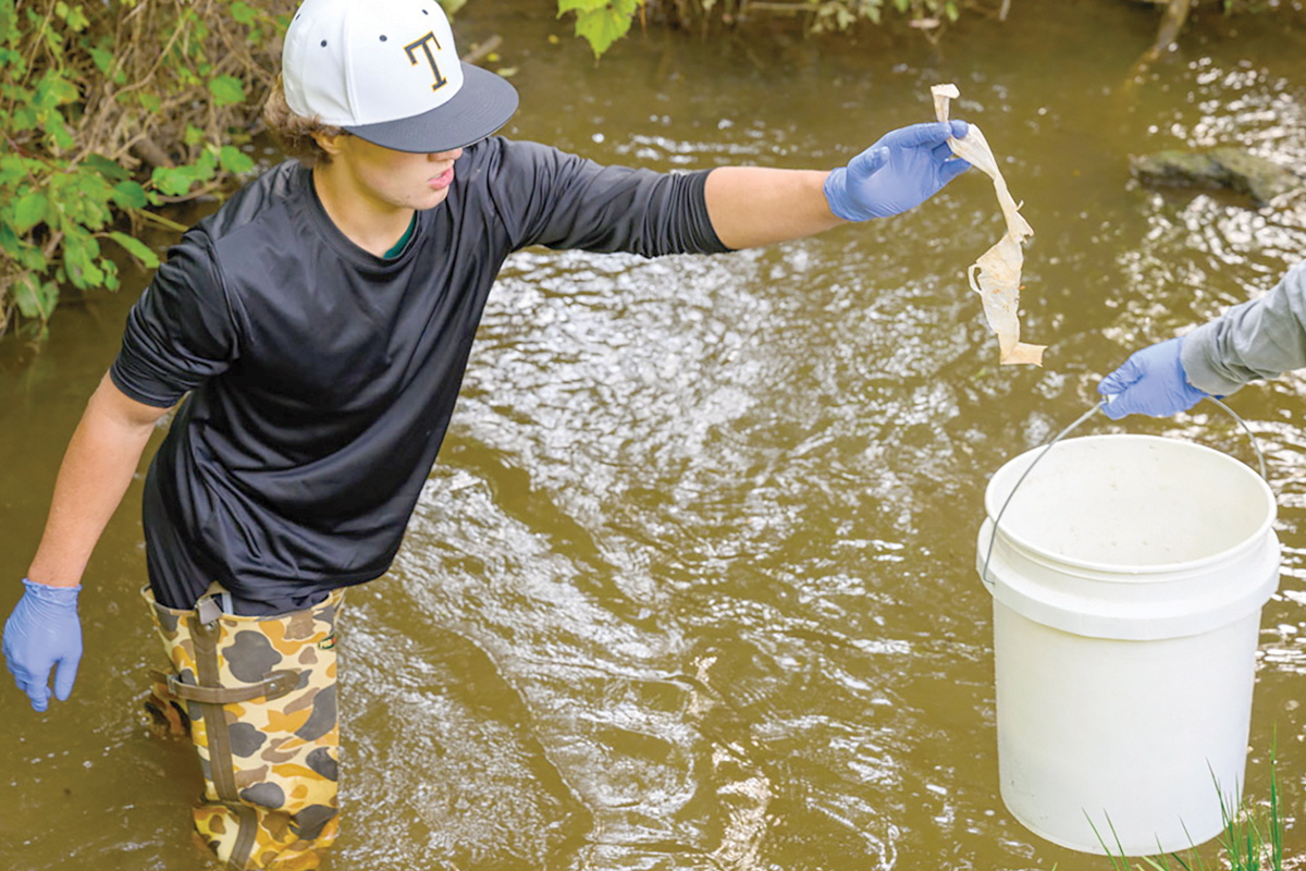 Tuscola High School student August Fama helps collect plastics from Waynesville’s Richland Creek watershed. WCU photo