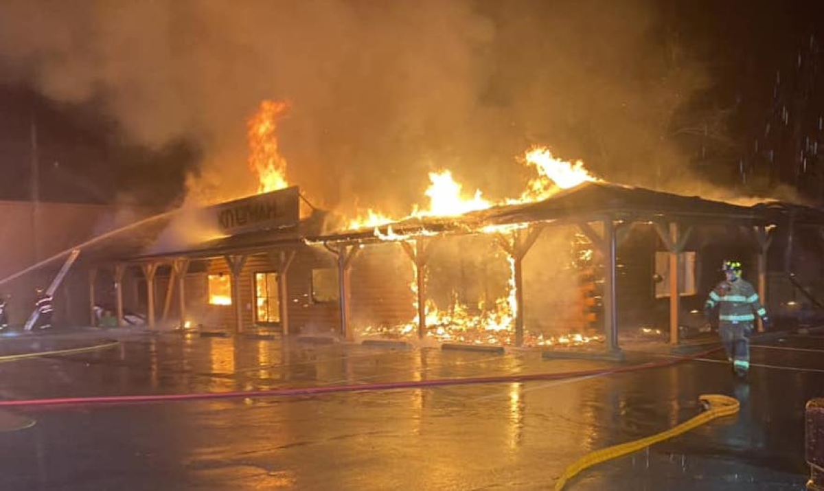 A firefighter walks away from the burning Kituwah LLC buidling 