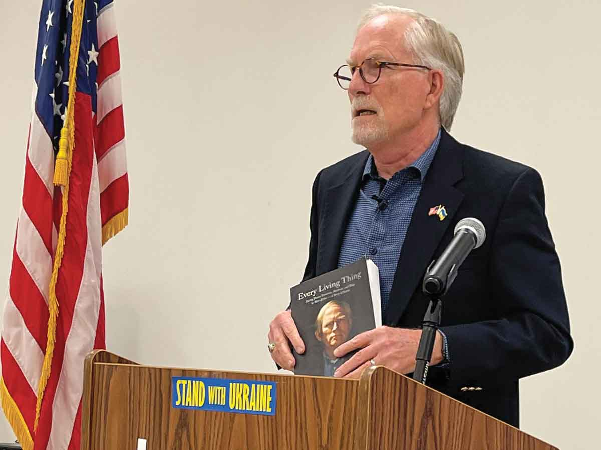 David Crane holds up a copy of his book, ‘Every Living Thing: Facing Down Terrorists, Warlords, and Thugs in West Africa—A Story of Justice.’ Kyle Perrotti photo