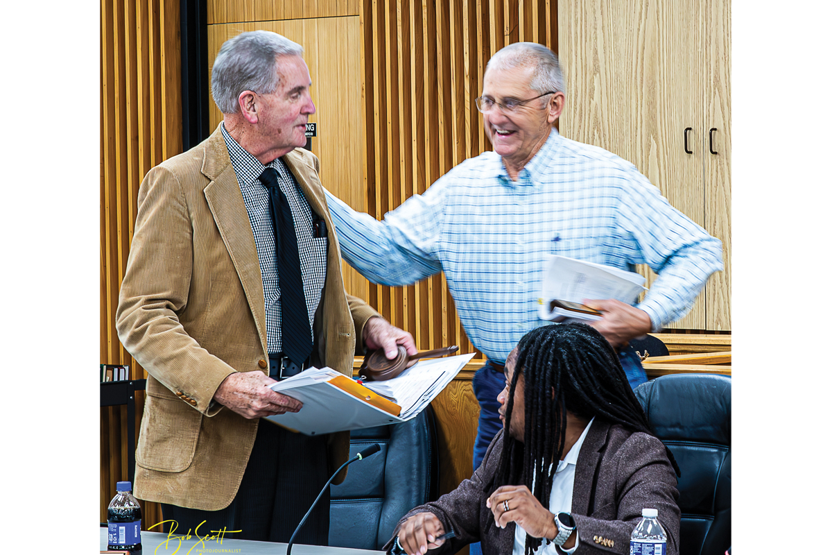 The outgoing chair, Commissioner Paul Higdon (right), congratulates  the new chair, Commissioner Gary Shields. Bob Scott photo