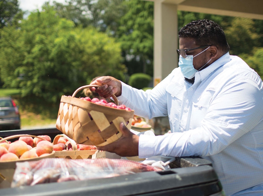 Pastor Rubi Pimentel of Hendersonville Spanish Church unloads produce from a local farm to feed community members in need. Photo by Colby Rabon