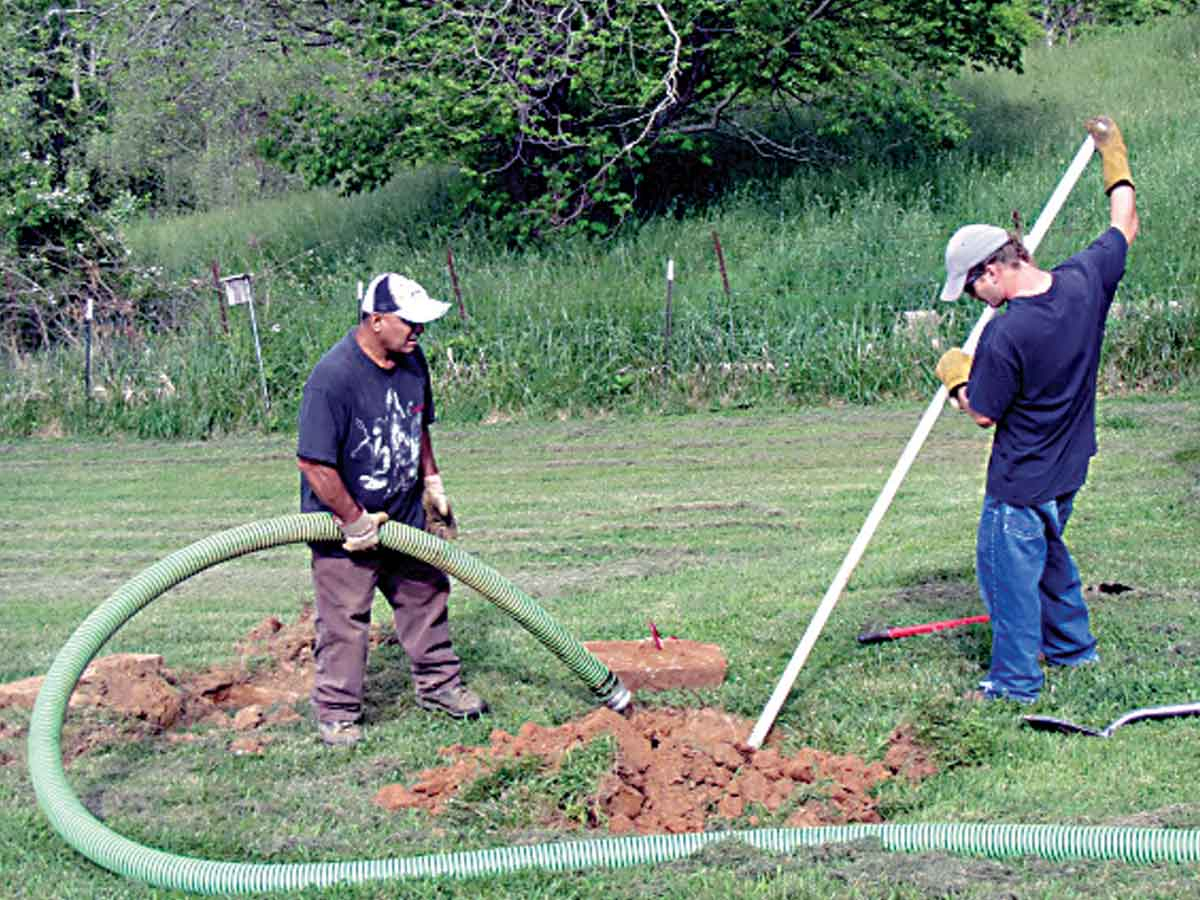 Workers repair a failing septic system. Donated photo