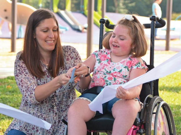 Maggie Garrett (right) helps Haywood County Schools Physical Therapist Mary Beth Brown cut the ribbon on Waynesville’s new all-abilities playground. Cory Vaillancourt photo