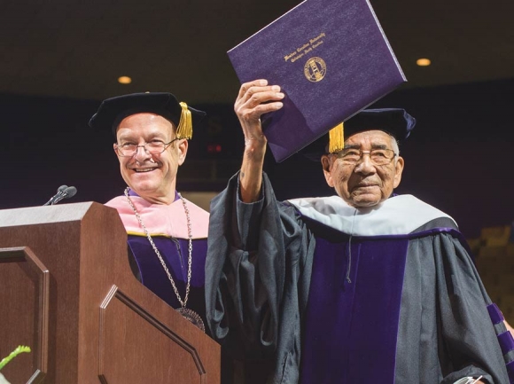 The late Jerry Wolfe, a Beloved Man in the Eastern Band of Cherokee Indians, holds his honorary doctorate from WCU while standing alongside Chancellor Belcher in May 2017. WCU photo