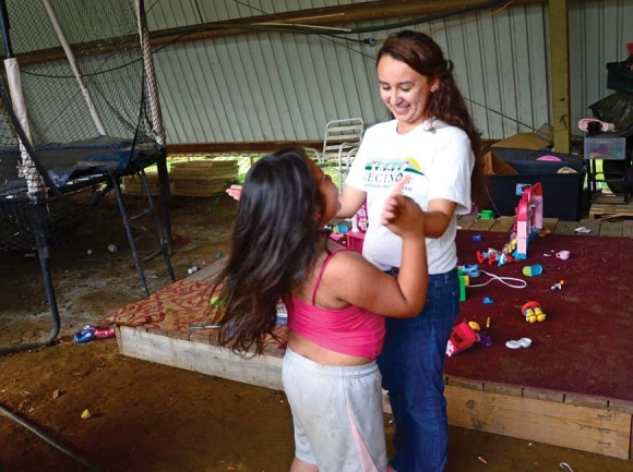 A Vecinos worker spends some down time playing with a child of one of the farmworkers. Holly Kays photo