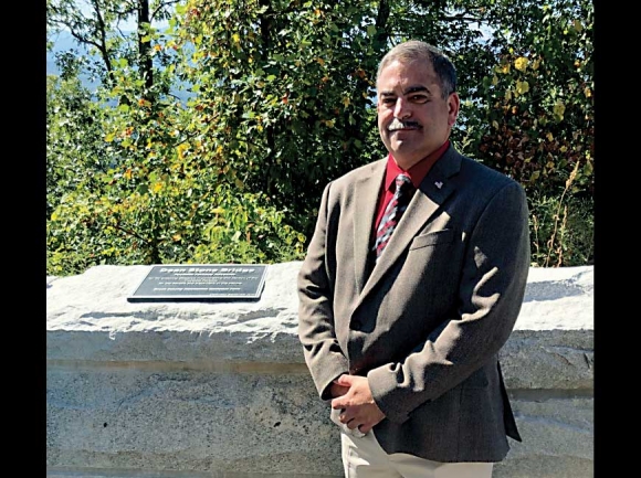 Neal Stone stands in front of the plaque honoring his father, Dean’s, contributions to the Foothills Parkway. NPS photo
