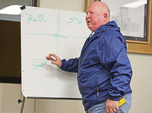 Commissioner Boyce Deitz takes to a whiteboard to sketch out his opposition to consolidation following a Jan. 29 public hearing on the matter. Holly Kays photo