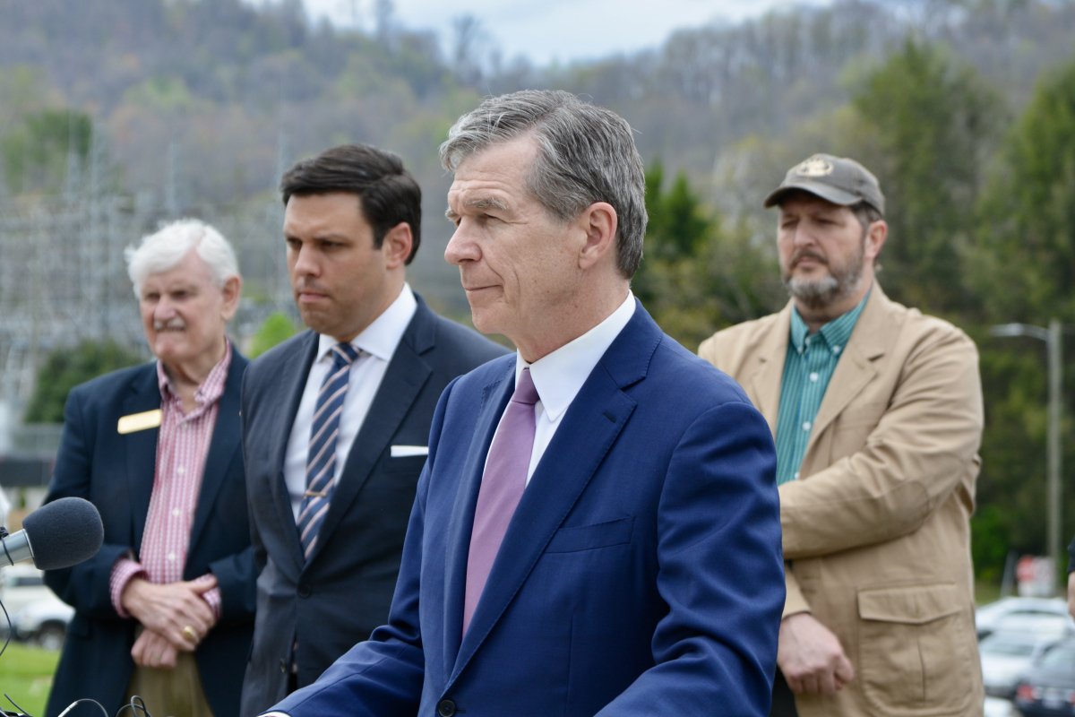North Carolina Gov. Roy Cooper (center) speaks to reporters in Canton on April 6 as (left to right) Clyde Mayor Jim Trantham, Canton Mayor Zeb Smathers and Haywood County Commission Chair Kevin Ensley look on from behind. 