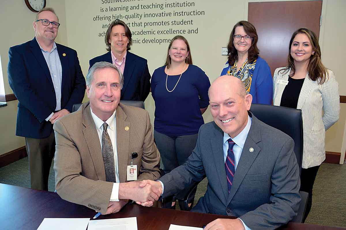 Don Tomas, left, SCC president, and Tony Floyd, Mars Hill University president shake hands after signing the agreement to create the Mountain Lion-Southwestern Promise. 