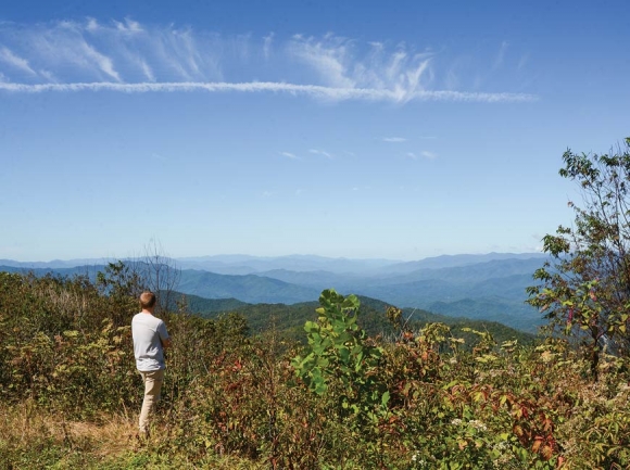 Jordan Smith, of Mainspring Conservation Trust, looks out from the 5,462-foot view atop a Jackson County property slated for conservation. Holly Kays photo