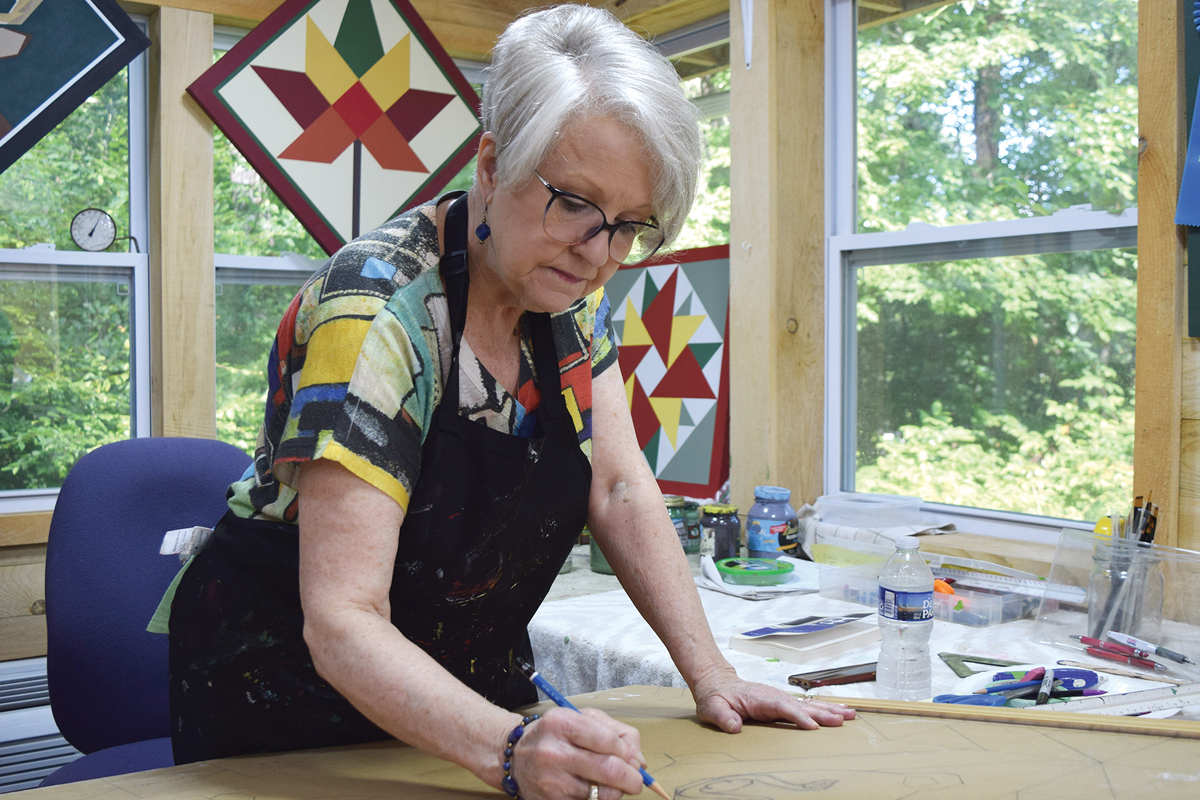 Deborah Freedman sketches out a quilt block in her studio prior to pulling out her paint brushes to apply the durable paints she uses for the finished product.