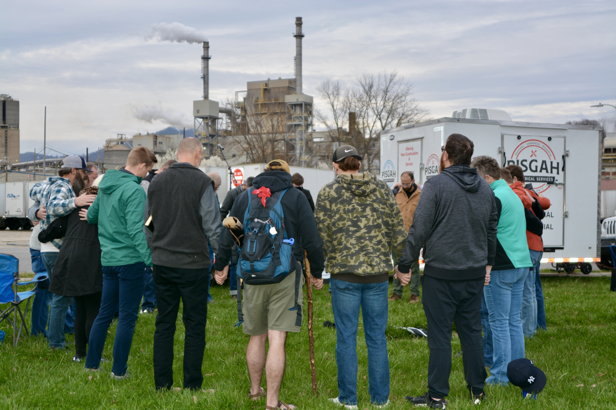 A prayer circle forms during a vigil held for workers in Canton on March 9. 