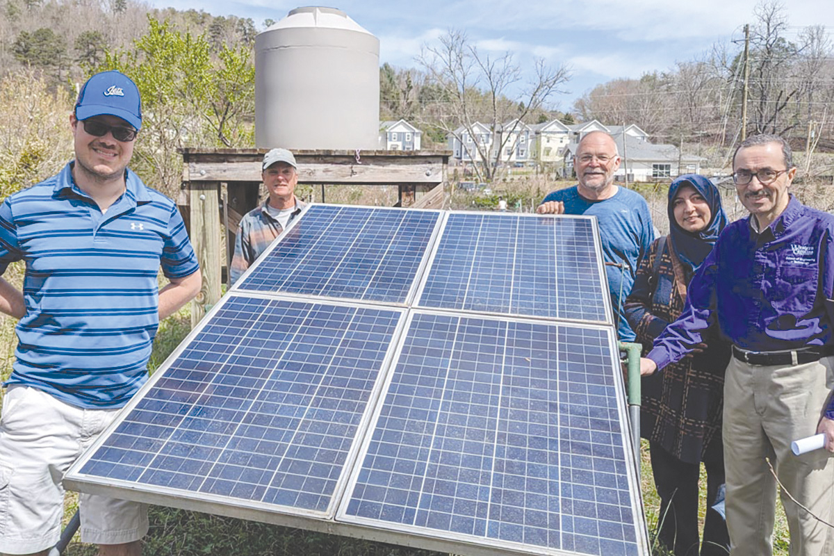 The team surrounds the newly functioning solar power system. WCU photo