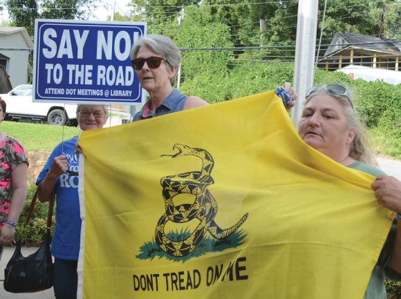 Protestors gather outside the Sylva Town Hall in advance of the meeting, carrying signs and distributing &#039;Say No To The Road&#039; bracelets. Holly Kays photo