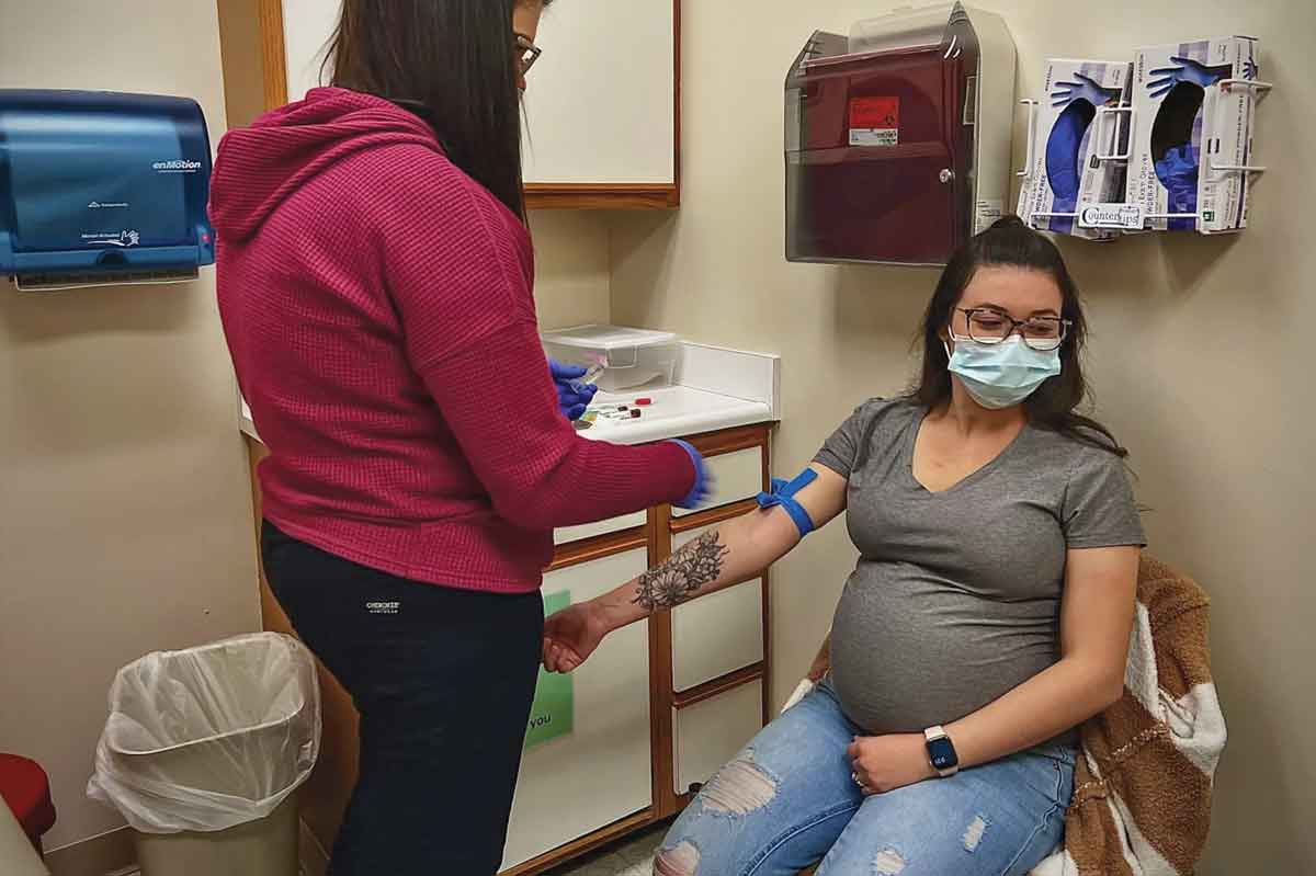 Allie Custer (left) draws a vial of blood from pregnant patient Ana. Ana planned to deliver at Mission Hospital in Asheville. Clarissa Donnelly-DeRoven photo