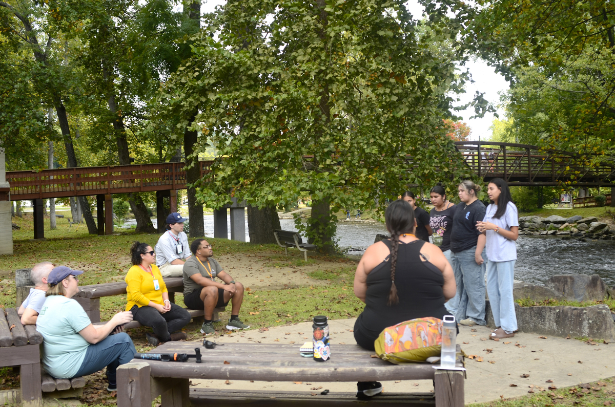 Standing on the banks of the Oconaluftee River, leaders of the youth-led North American Indian Women’s Association Daughters share with Outdoor Economy Conference attendees the importance the river, or Long Person, holds in their culture. 