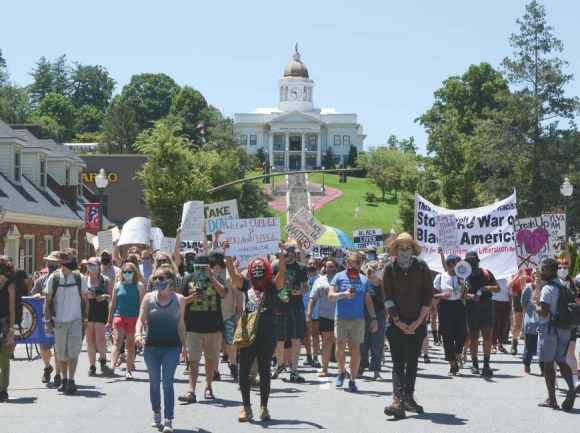 Protestors walk below the hill where the statue perches during a July 2020 march opposing the monument. Holly Kays photo