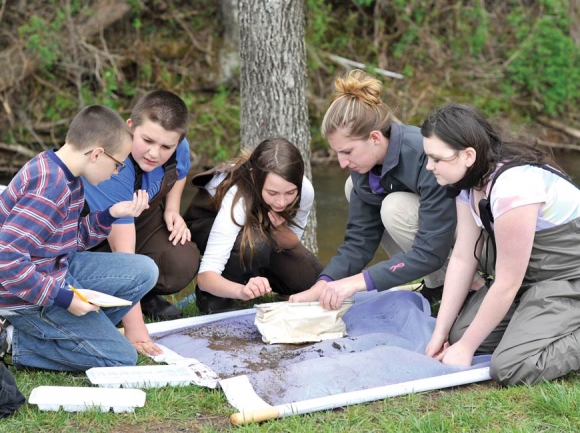 Western Carolina University senior Brittany Timpson shows an inquisitive group of elementary students in the Watershed Moments program a macro invertebrate. Inset, below: Liam Tormey has been an avid participant in the program. 