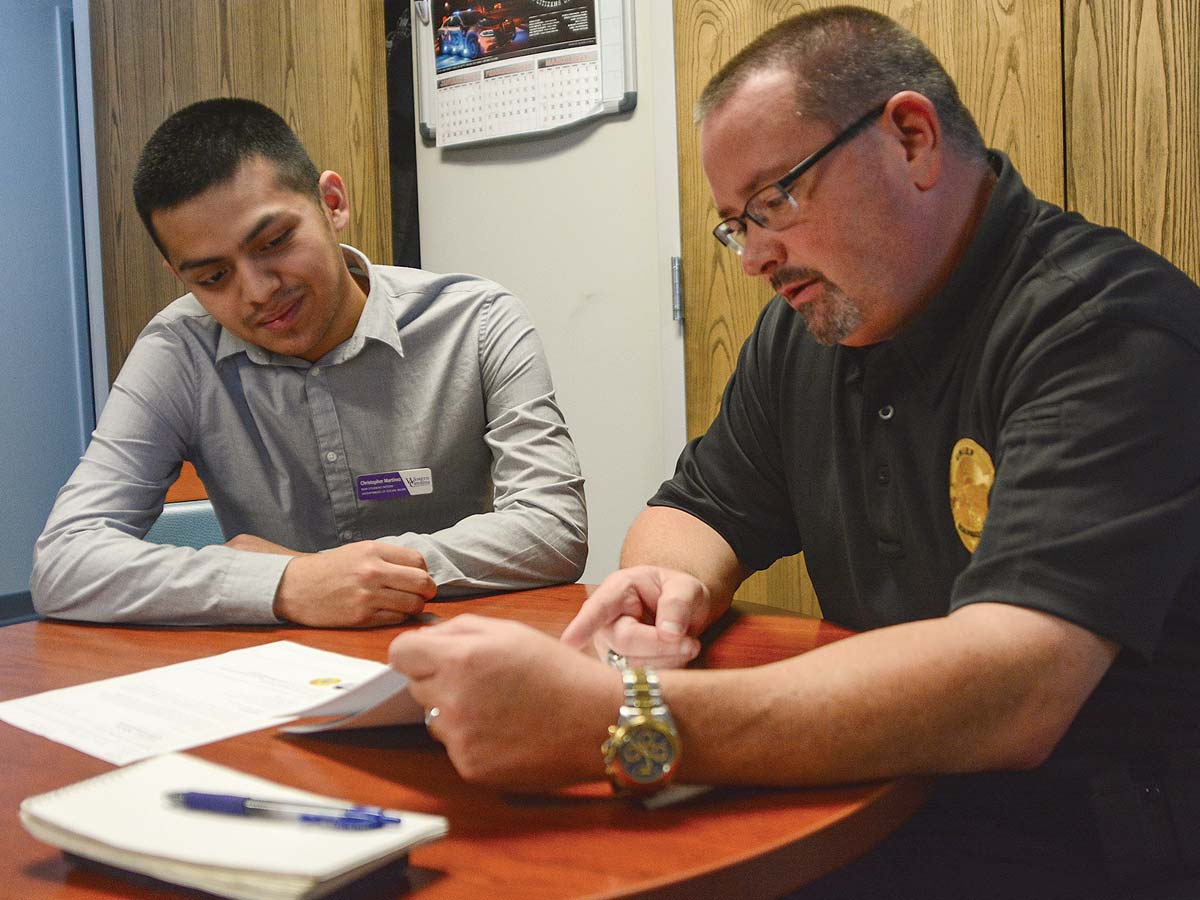 Police Chief Chris Hatton (right) reviews files with social work intern Chris Martinez. Holly Kays photo