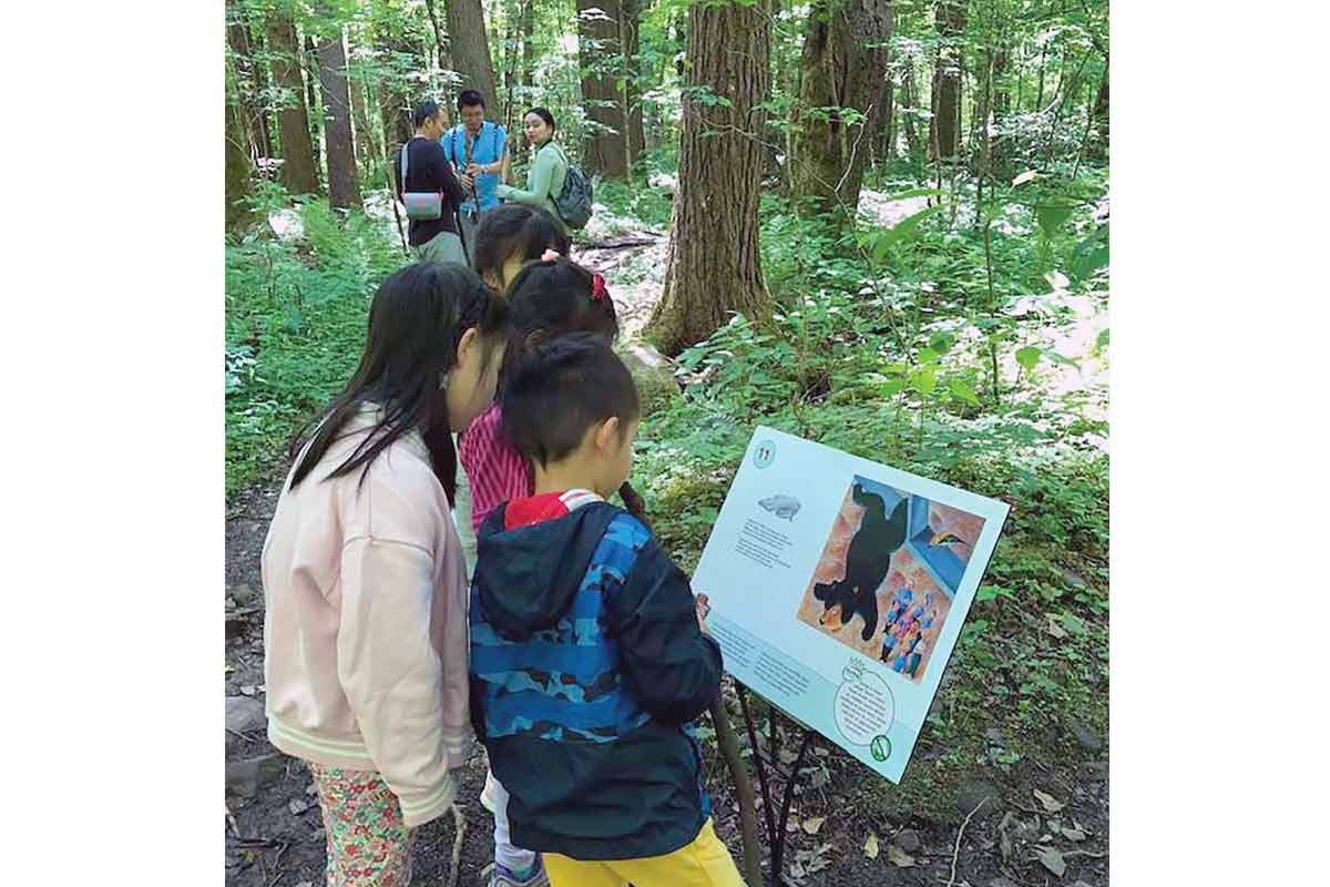 Young park visitors examine a  Storybook Trail sign. NPS photo 