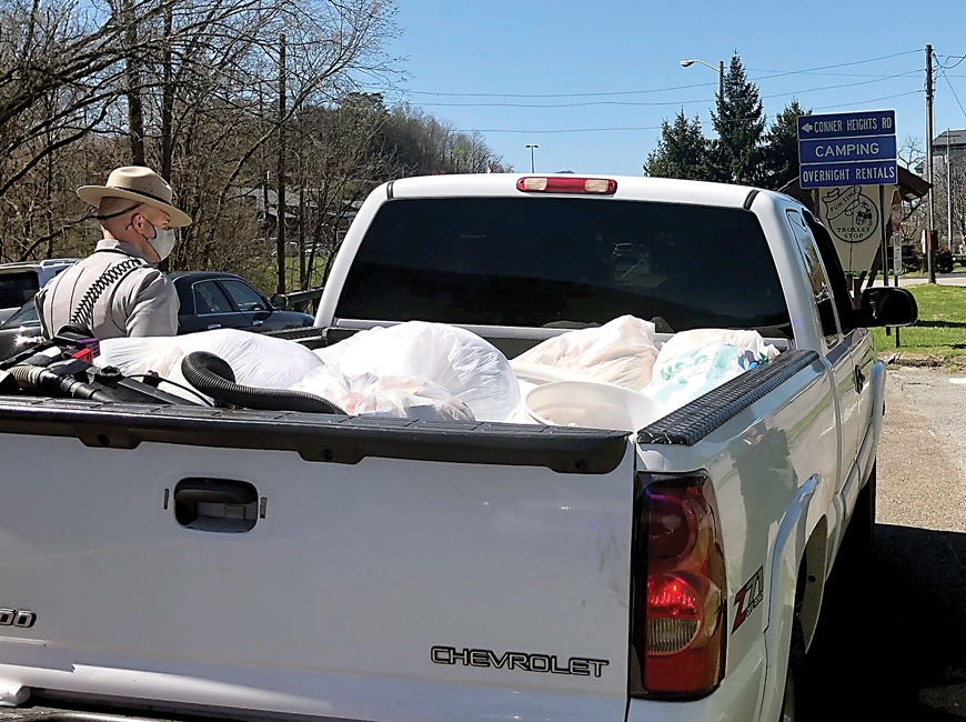 A park ranger speaks with the driver of a truck hauling unsecured garbage. NPS photo