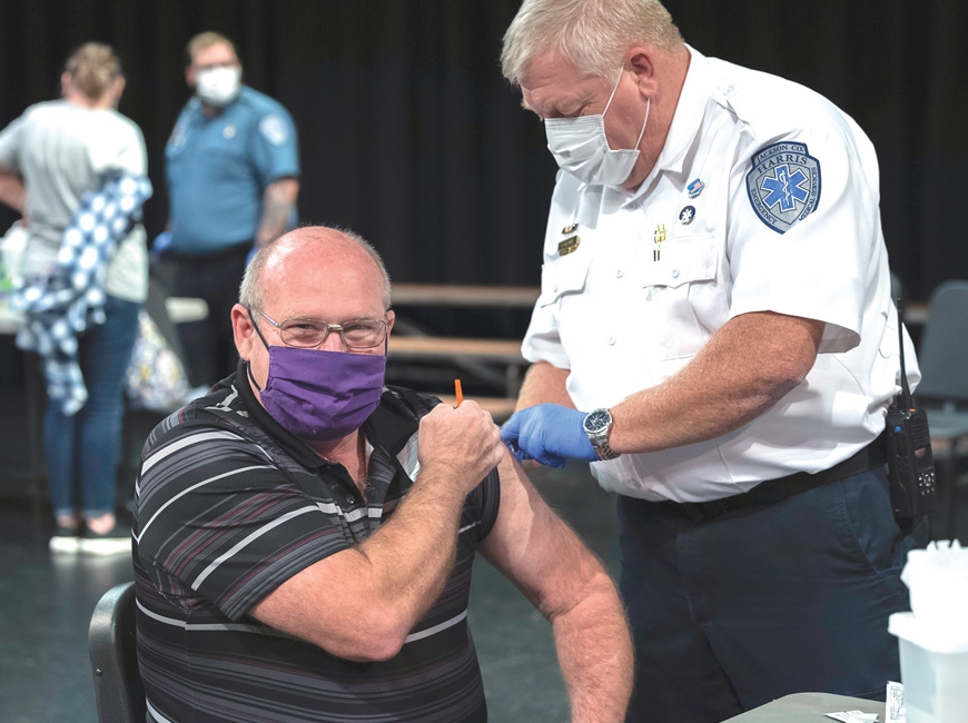 EMS Supervisor Toby Moore vaccinates Mike Taylor during a January clinic for employees of Jackson County Public Schools. David Profitt/JCPS photo