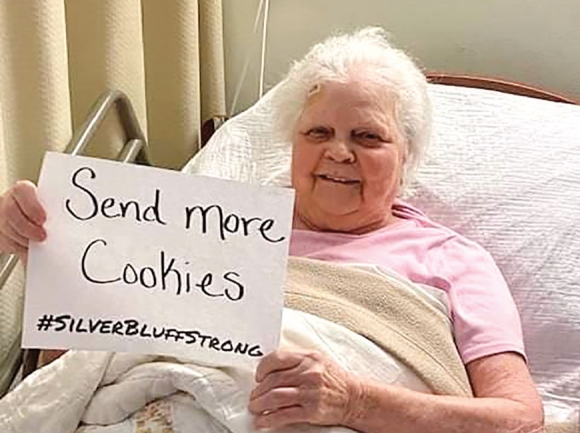 Peggy Daniels holds up a sign requesting more cookies be delivered to her at Silver Bluff Village in Canton for her 84th birthday April 18.