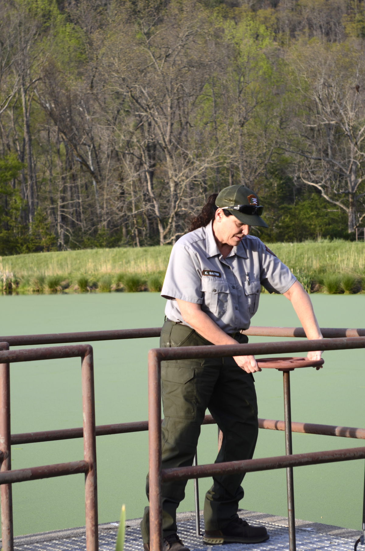Water operator Kim Baxter adjusts the valve that regulates flow between the third Cades Cove lagoon and the drain field below. 