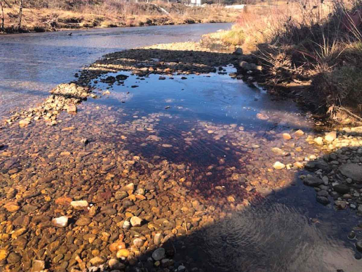 In a photo taken Feb. 1, black liquor deposits sit in the Pigeon River. AECOM photo