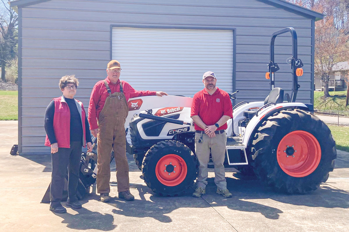 Haywood County Farm Bureau Board member Marie Ferguson (left to right), board President Don Smart and Central Haywood High School agriculture teacher Kevin Baily pose by the school’s new tractor. Haywood County Farm Bureau photo
