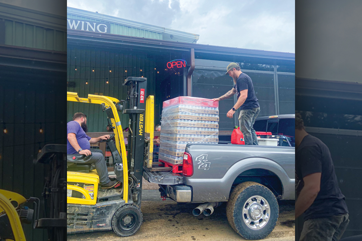 Innovation Brewing staff prepare canned water  for flood victims. Chelsea Brinton photo