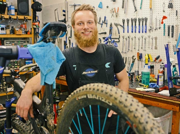 Zach Moss spends a lot of time in the shop working on repairs (above) but also enjoys interacting with customers (below). Holly Kays photos