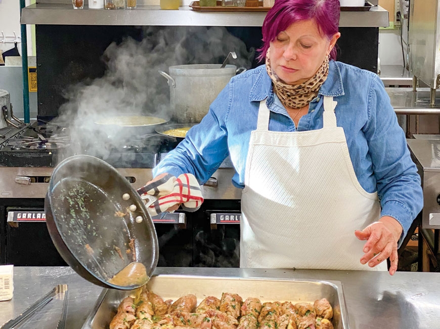 Chef Sandra Stefani deglazes a pan over Veal Rollatini.