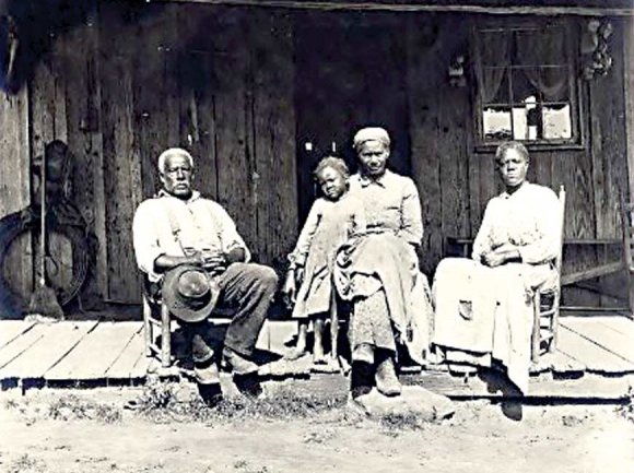 In a photo taken between 1890 and 1903, an African-American family sits on a front porch in the Great Smokies region. W.O. Garner Photograph Collection 