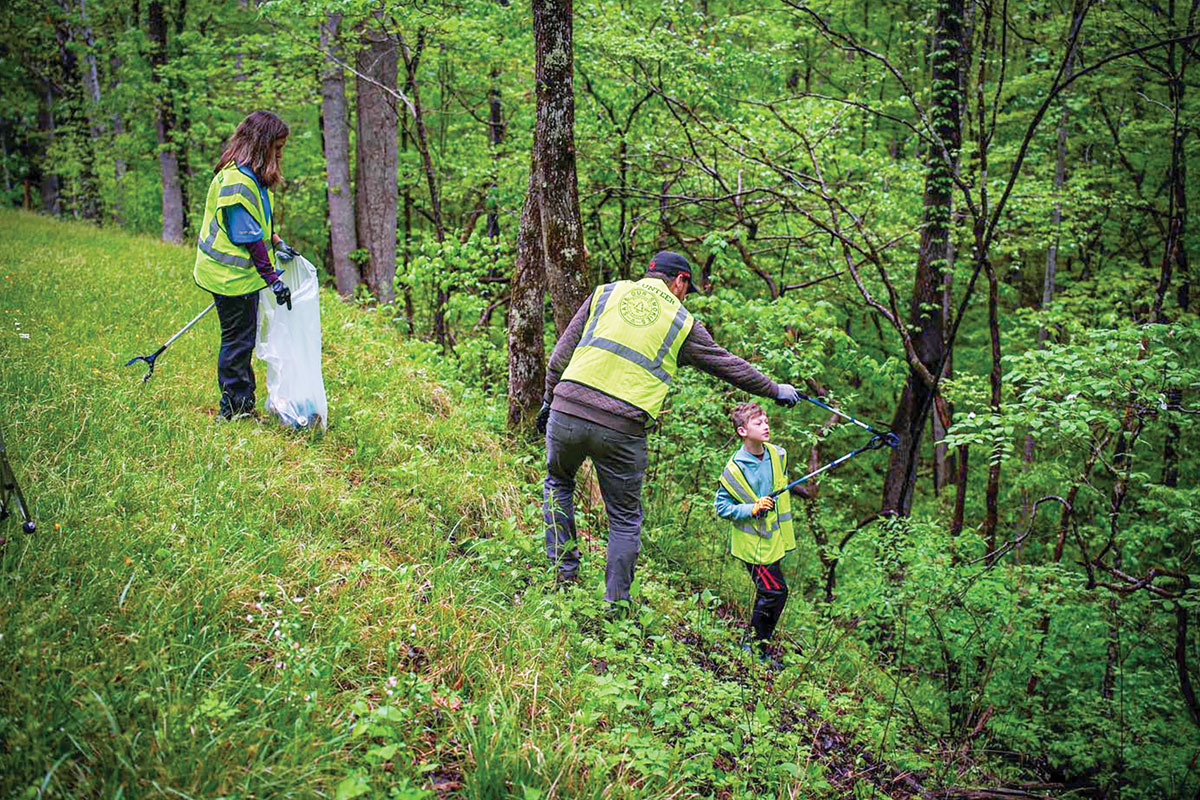 A young volunteer reaches for a piece of litter during the 2023 Spring Clean litter pickup in Great Smoky Mountains National Park. Save Our Smokies photo 