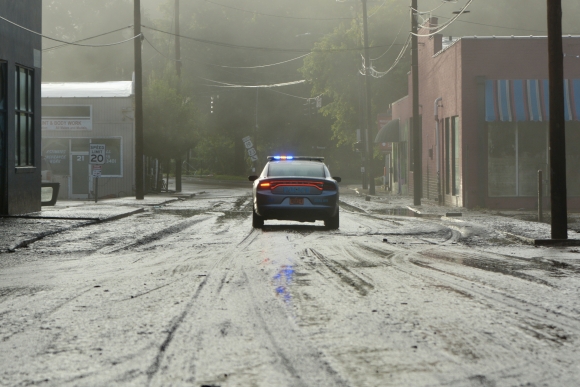 A police car blocks a mud-slicked road in Downtown Canton around 7 a.m. on the morning of Aug. 18. 